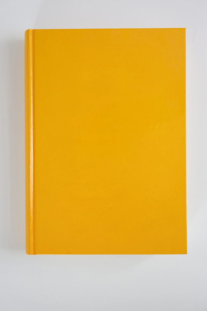 Yellow Book with Blank Cover on Light Background – Centered Top View as Mockup Template