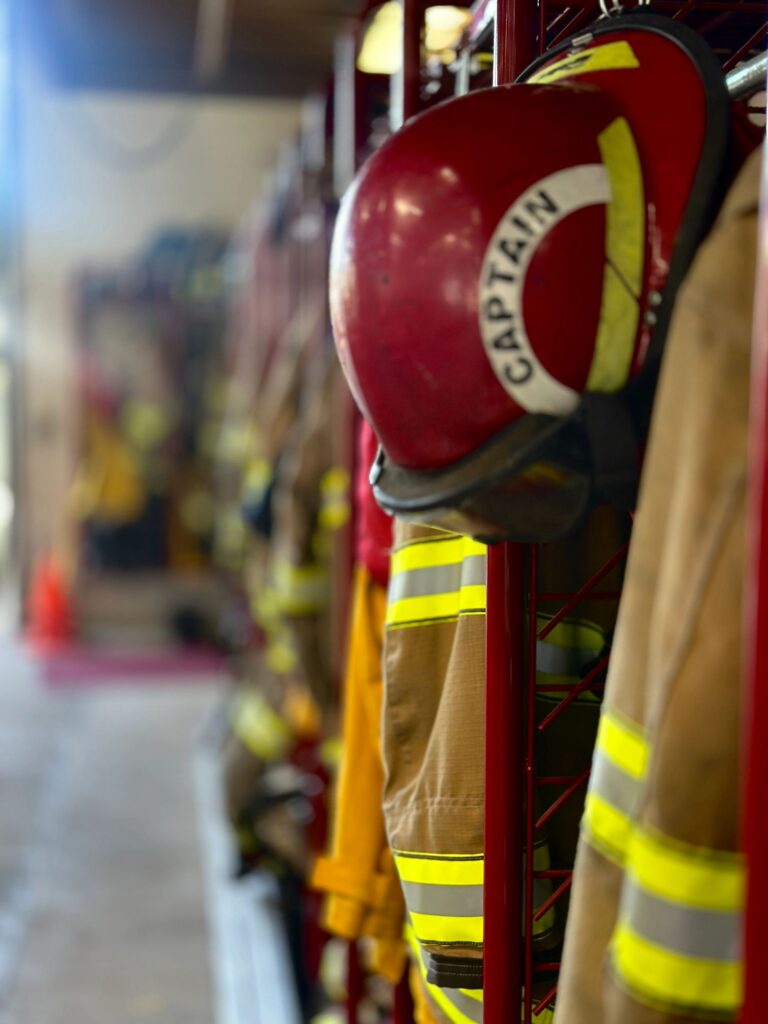 Closeup Focus on Foreground Defocused Background Firefighting Turnout Gear Hanging in Fire Station